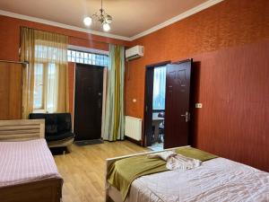 トビリシにあるNana's Apartment with gardenのベッドと椅子と窓のある寝室 +2枚の写真