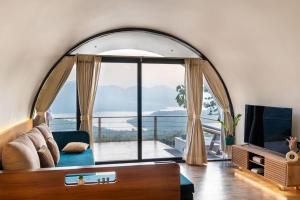 an arched living room with a large arched window at Kyuka - Kizuna in Mulshi