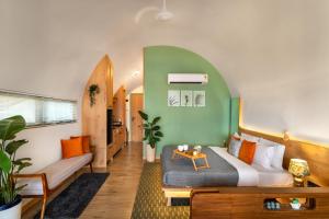 a bedroom with a bed and a couch and a table at Kyuka - Kizuna in Mulshi