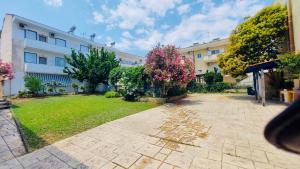 a courtyard of a building with pink flowers in the yard at Holiday House 3- Kallithea Halkidiki in Kallithea Halkidikis