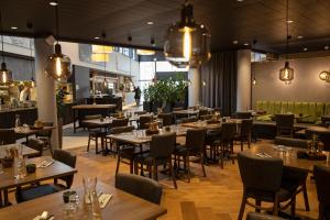 a restaurant with wooden tables and chairs and lights at Hotel Pommern in Mariehamn