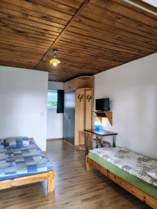 a bedroom with a bed and a table in a room at Dom Wczasowy Dogoda in Zełwągi