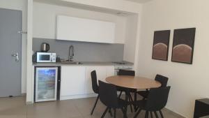 a kitchen with a wooden table and black chairs at Beyond 42 Eilat in Eilat