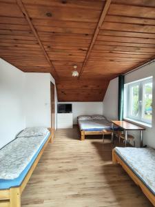 a room with two beds and a wooden ceiling at Dom Wczasowy Dogoda in Zełwągi