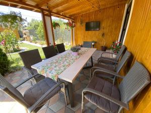 a wooden table and chairs on a patio at Vila Luna in Năvodari