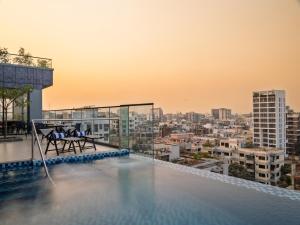 a rooftop pool with a view of a city at W Residence Living in Dhaka