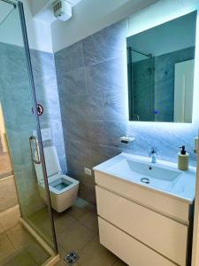 a bathroom with a sink and a toilet and a mirror at Tirana Center Apartments in Tirana
