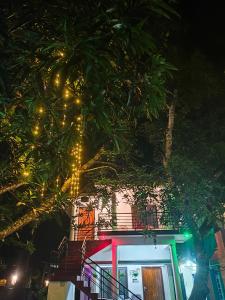 瓦尔卡拉Beach Combers Resort的树前有圣诞灯的建筑