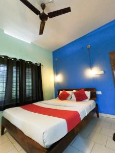 瓦尔卡拉Beach Combers Resort的卧室里有一张大床，墙壁是蓝色的