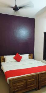 瓦尔卡拉Beach Combers Resort的床上有红色枕头