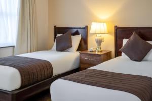 a hotel room with two beds and a lamp at Bosworth Hall Hotel & Spa in Market Bosworth