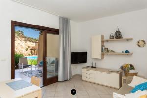 a living room with a couch and a television at Hotels Too - Home Paradiso in Costa Paradiso