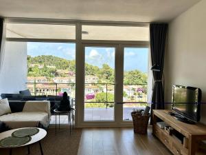 a living room with a couch and a large window at Cala Morisca full AC Sea View Home in Tossa de Mar