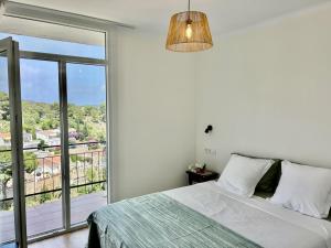 a bedroom with a bed and a large window at Cala Morisca full AC Sea View Home in Tossa de Mar +25 photos