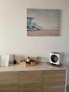 a microwave sitting on top of a dresser next to a beach at Avô Moreira Beach House in Póvoa de Varzim