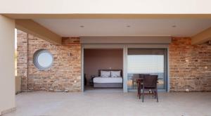 a bedroom with a bed and a table with a chair at Ground Floor Studio by the sea in Monemvasia