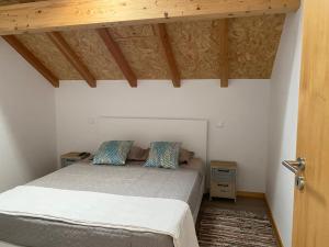 a bedroom with a bed and a wooden ceiling at Avô Moreira Beach House in Póvoa de Varzim