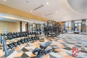 une salle de sport avec une rangée de tapis de course et de machines dans l'établissement Apec Mandala Mui Ne by LHG - Sea View, Infinity Pool, 17m to Bàu Trắng Bình Thuận, à Mui Ne