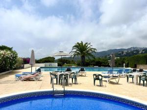 a swimming pool with tables and chairs next to a pool at Cala Morisca full AC Sea View Home in Tossa de Mar