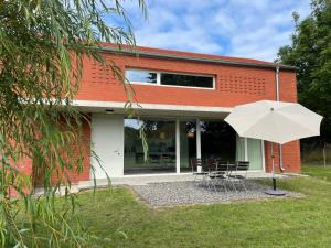 a white umbrella sitting in front of a building at Modernes Architektenhaus direkt am Golfplatz Schloss Ranzow. in Lohme