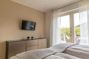 a bedroom with a bed and a tv and a window at Ferienwohnung Waldblick mit Terrasse und Garten - familienfreundlich in Heringhausen
