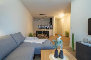 ein Wohnzimmer mit Sofa und Tisch in der Unterkunft Herz von Kellenhusen 5 mit Terrasse und Sauna in Kellenhusen