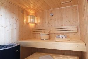 - un sauna avec un banc et un seau dans l'établissement Suite Relax 3.0 - Die elegante Ferienwohnung mit Dachterrasse, Meerblick und Sauna, à Fehmarn 18 autres photos