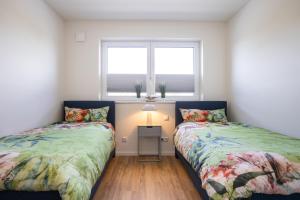 a bedroom with two beds and a window at Penthouse 18 - mit Dachterrasse und Sauna in Dorum