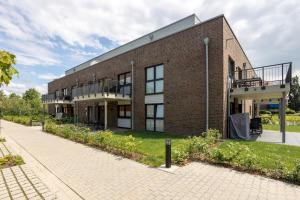 a brick building with balconies on the side of it at Penthouse 18 - mit Dachterrasse und Sauna in Dorum