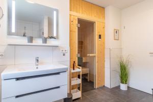 ein Badezimmer mit Waschbecken und Spiegel in der Unterkunft Kellenhusen Tor 22 - strandnah mit Sauna und Balkon in Kellenhusen + 28 Fotos