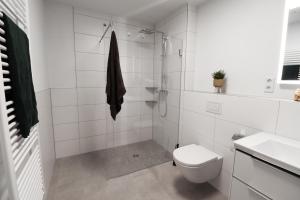 a white bathroom with a toilet and a sink at Lütte Koje - strandnah mit Sauna.Besonders familienfreundlich. in Butjadingen OT Tossens +15 photos