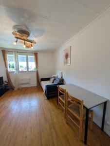 a living room with a table and a couch at Appartement T3 in Roanne