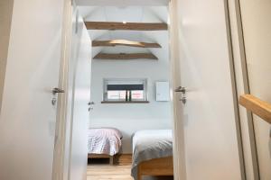 a small room with two beds and a window at Ferienwohnung Alter Stall - linke Seite für 3 Personen in Ohne +10 photos