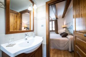 a bathroom with a sink and a bed in a room at Pichuana - dúplex 4 dormitorios 4 baños in Benasque
