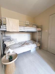 una stanza con due letti a castello e un tavolo di Le cottage de Mag a Cerences