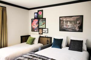 two beds in a room with pictures on the wall at Getaway Brussels Airport in Zaventem