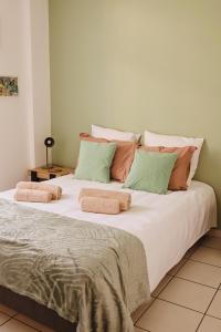 a large bed with several pillows on top of it at Maison Cléophée in Gujan-Mestras
