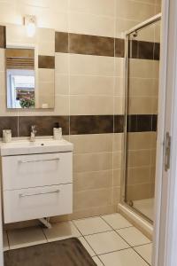 a bathroom with a sink and a shower at Maison Cléophée in Gujan-Mestras +14 photos
