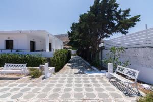 due panche sedute su un marciapiede accanto a un edificio di Villa Svoronou Athens Riviera a Áyios Nikólaos