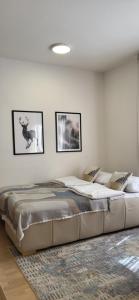 a large bed in a room with pictures on the wall at Mek lux Bjelasnica in Bjelašnica