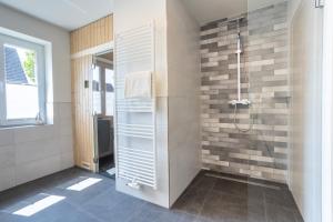 ein Badezimmer mit Dusche mit Glastür in der Unterkunft Villa Dornkamp 2 - Luxuriöse Ferienwohnung für 4 Personen inklusive Garten und Sauna in Timmendorfer Strand + 8 Fotos