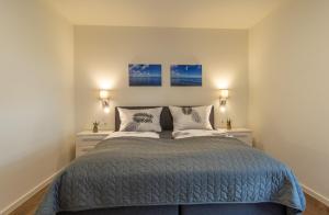 ein Schlafzimmer mit einem Bett mit zwei Kissen in der Unterkunft Kellenhusen Tor 19 - mit Sauna und Garten, Hunde willkommen in Kellenhusen