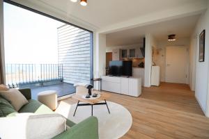 フェーマルンにあるBeltBlick 11 – Ferienwohnung mit unverbautem Meerblick & Dachterrasse!のソファとテーブルのあるリビングルーム