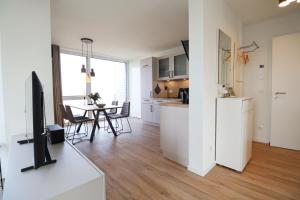 フェーマルンにあるBeltBlick 11 – Ferienwohnung mit unverbautem Meerblick & Dachterrasse!のキッチン、リビングルーム(テーブル、テレビ付)