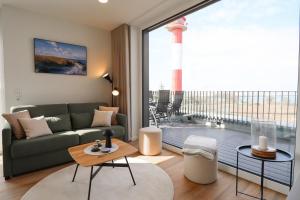 フェーマルンにあるBeltBlick 11 – Ferienwohnung mit unverbautem Meerblick & Dachterrasse!のソファと大きな窓のあるリビングルーム