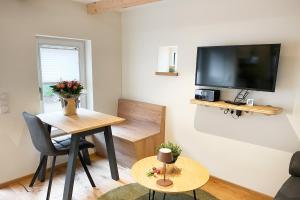 OhneにあるFerienhaus Altes Backhaus für 2 Personenのテーブルと壁にテレビが置かれたリビングルーム