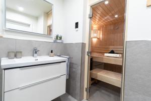 a bathroom with a white sink and a mirror at Dorumer Sielhuus 20 mit Sauna und Balkon in Dorum +17 photos