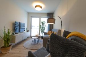 a living room with two couches and a tv at Dorumer Sielhuus 20 mit Sauna und Balkon in Dorum