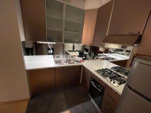 eine Küche mit braunen Schränken und weißen Arbeitsplatten in der Unterkunft Penshouse in Lecco + 15 Fotos