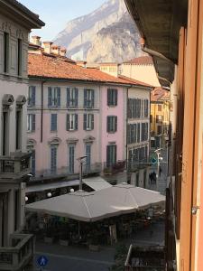 Blick auf eine Straße mit Gebäuden und einem Regenschirm in der Unterkunft Penshouse in Lecco